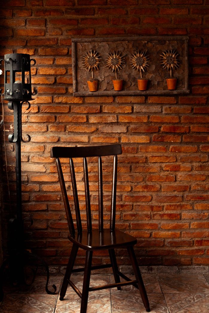 Crafting Captivating Headlines: Your awesome post title goes here Warm rustic interior features a wooden chair against a red brick wall with metal decor.